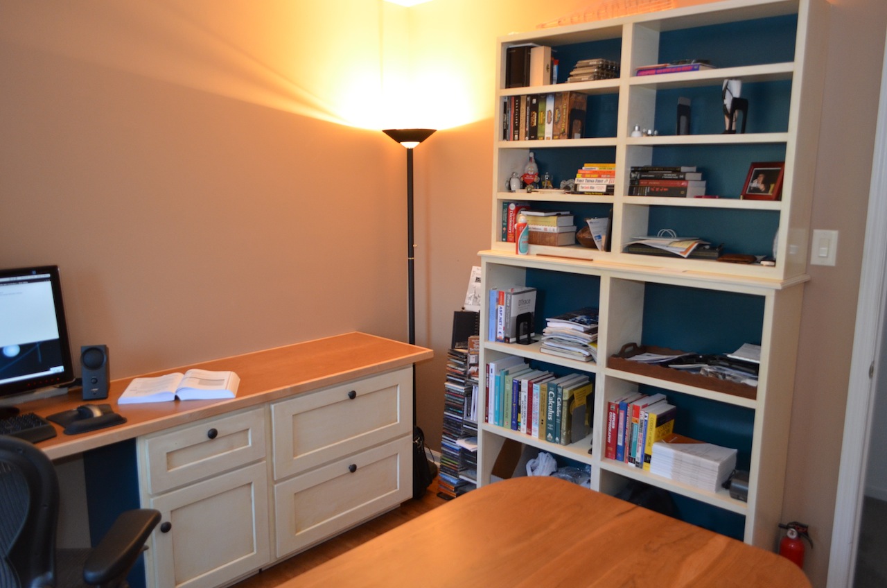 Brian's Office - table in foreground, more shelving with books, filing cabinets, etc.