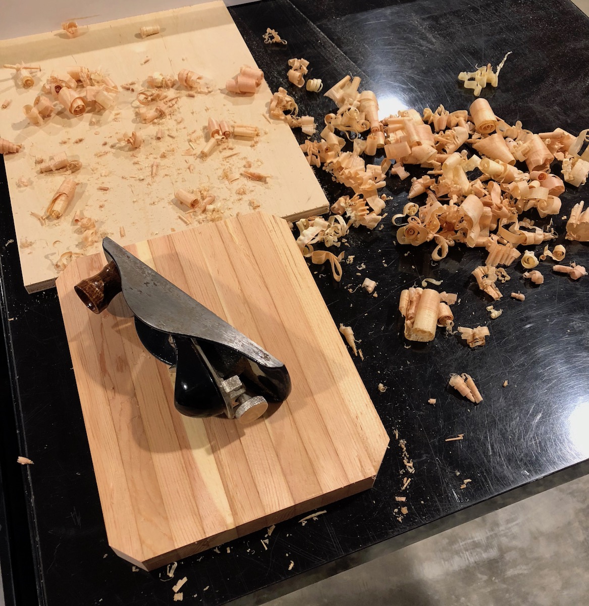 block plane and shavings around a cutting board