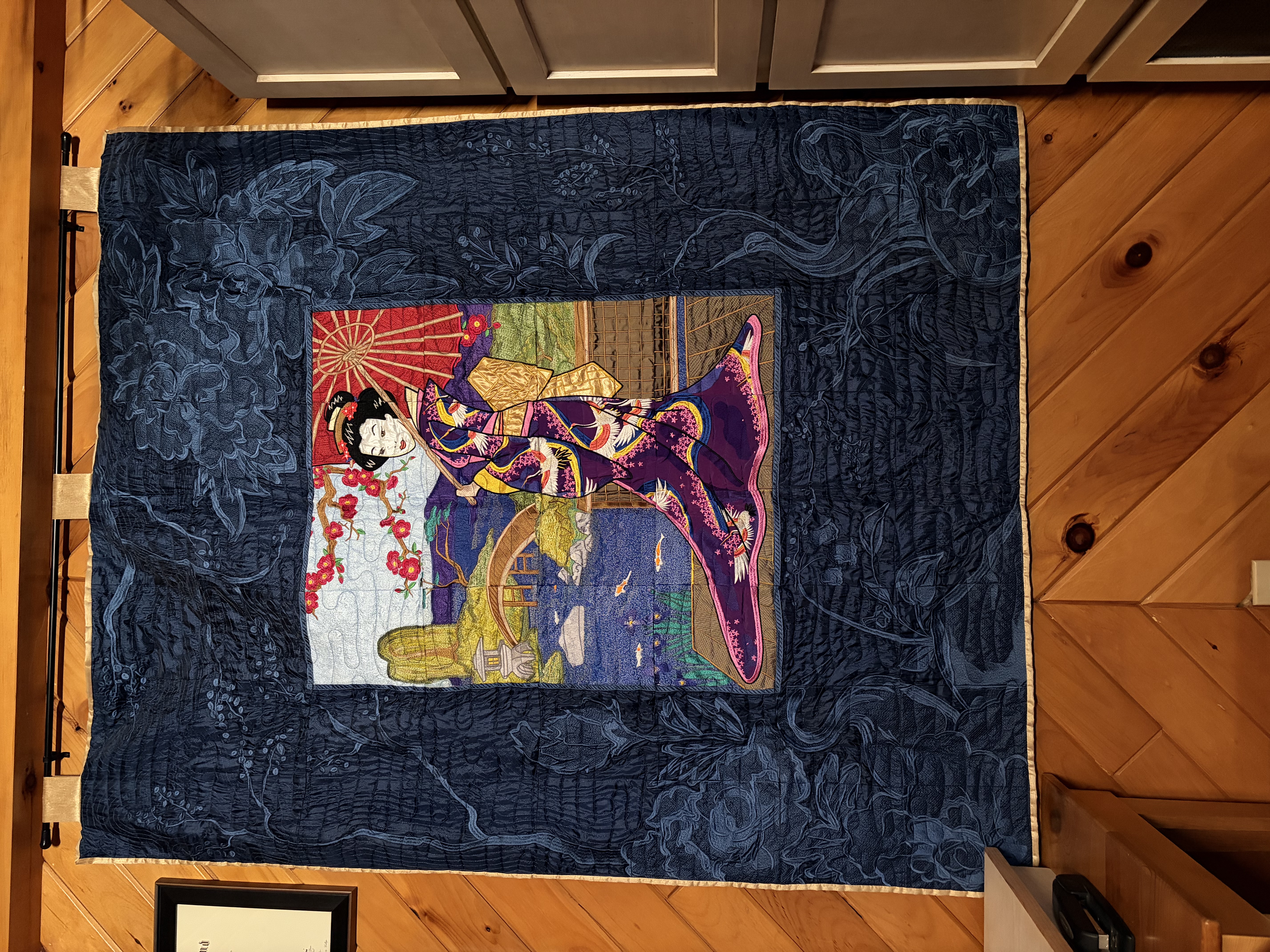Embroidered art quilt in bright colors for central image of a Japanese woman, with blue borders