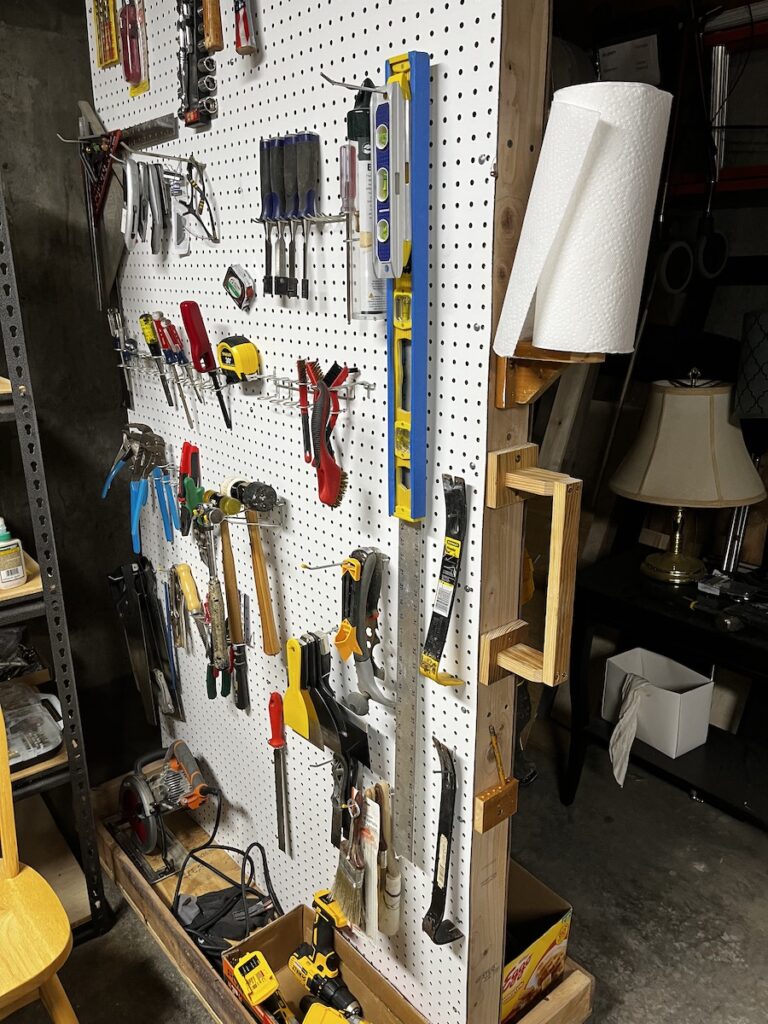 white pegboard tool storage rack, on mobile base.
