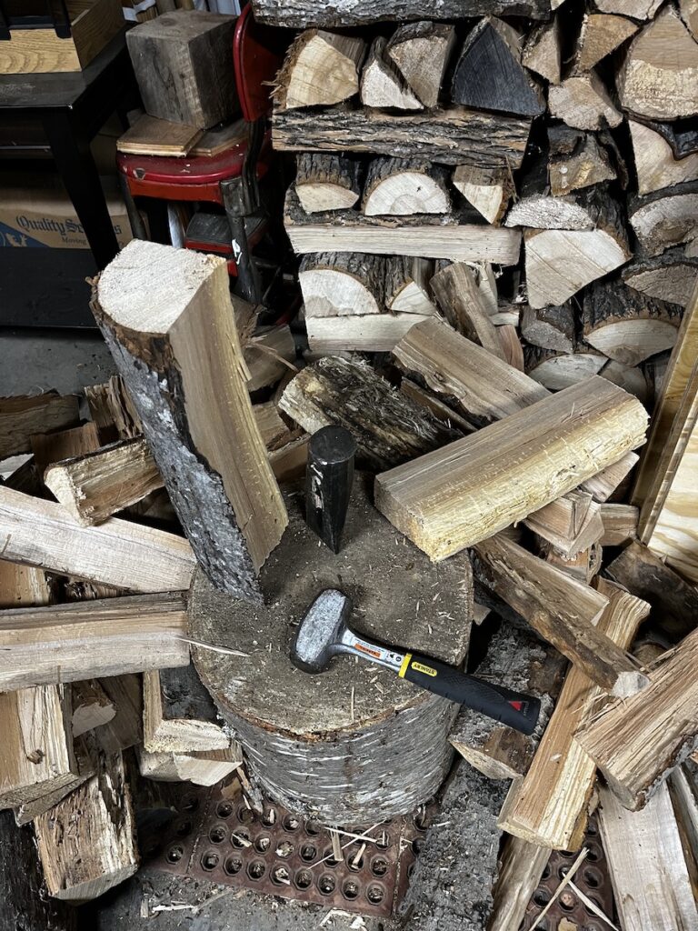 Splitting firewood into smaller cross sections with wedge and small sledge