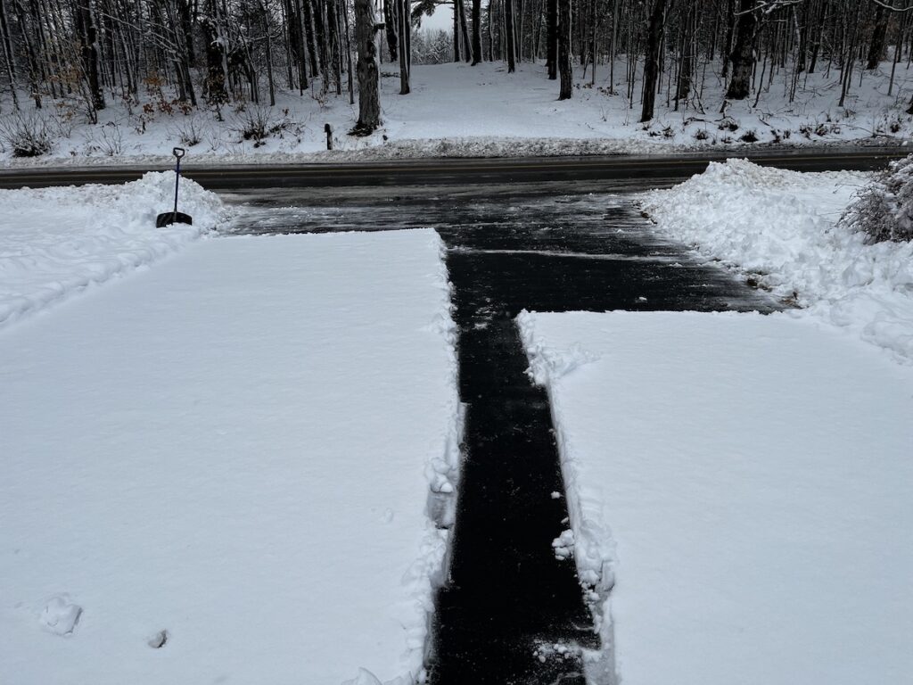 Shoveling snow from the driveway, partially done.