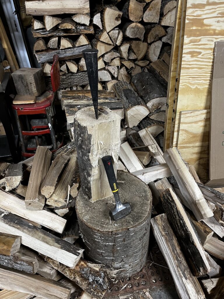 Splitting wood with a wedge and a five pound sledge.